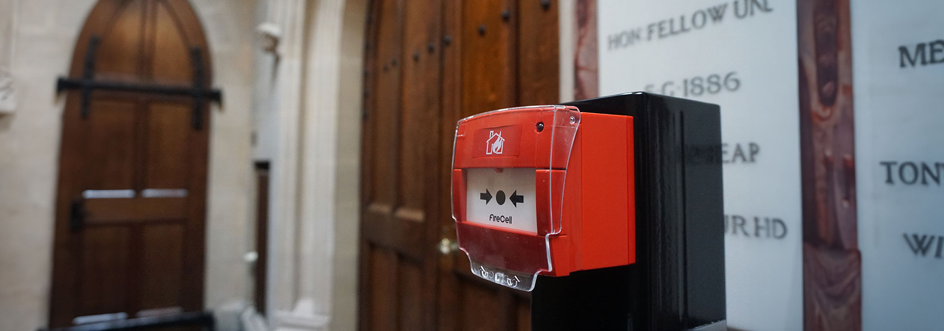 Close-up view of a red fire alarm inside a building. The fire alarm is prominently displayed, featuring a red casing with visible buttons and indicators. The image captures the essence of a critical safety device, emphasising the importance of fire alarm systems in protecting lives and property.