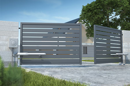 Grey swing gate opening in front of a house